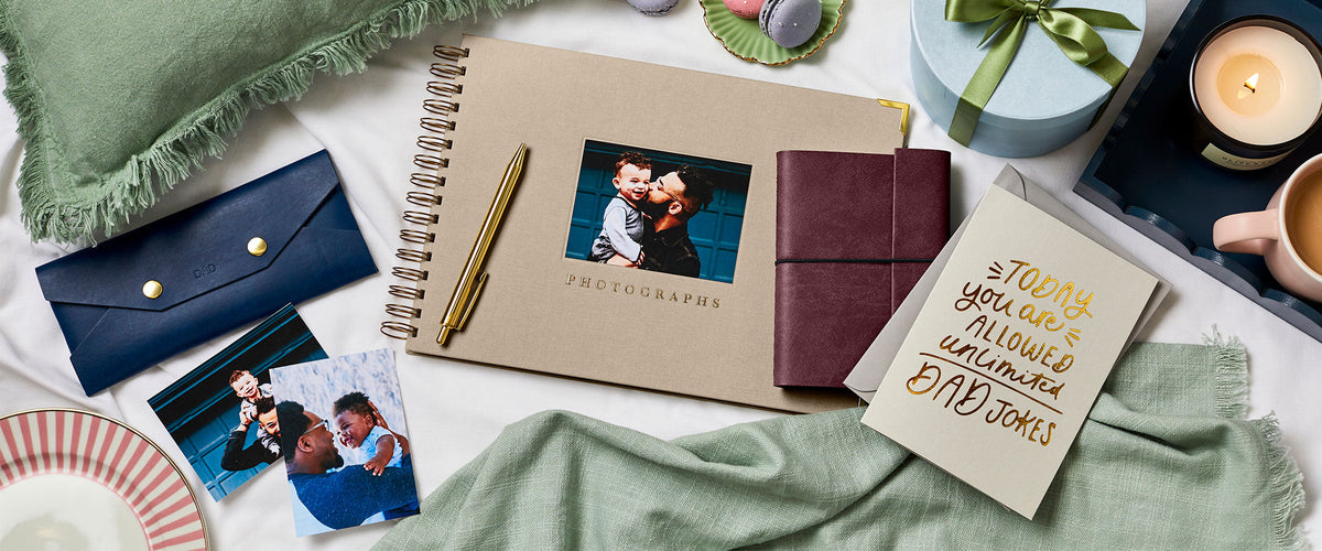 Martha Brook Personalised Photo Album, Vegan Leather A5 Classic Notebook, Vegan Leather Glasses Case and Father's Day Card on a blanket with a cup of tea and a candle