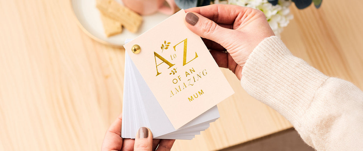 Martha Brook Personalised A-Z of an amazing Mum being held above a wooden table