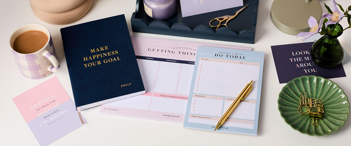 Martha Brook Personalised Happiness Planning Stationery Bundle on a desk with a cup of tea
