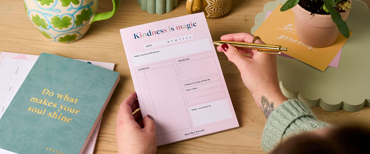 Martha Brook Personalised Self-Care Stationery Bundle with a hand holding a gold pen