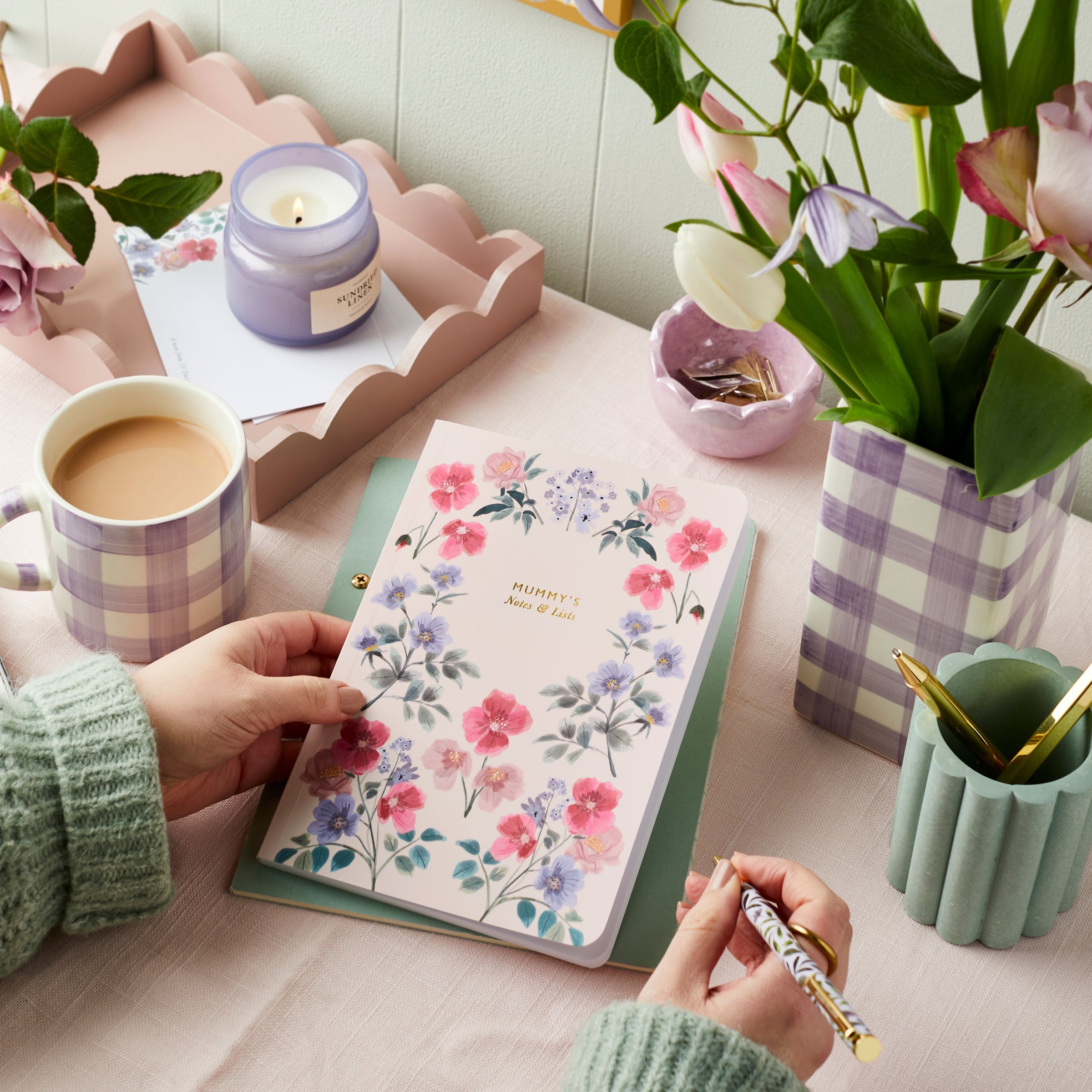 Martha Brook Personalised Wild Floral Notebook with hands on a table with a mug of tea and flowers in a gingham vase