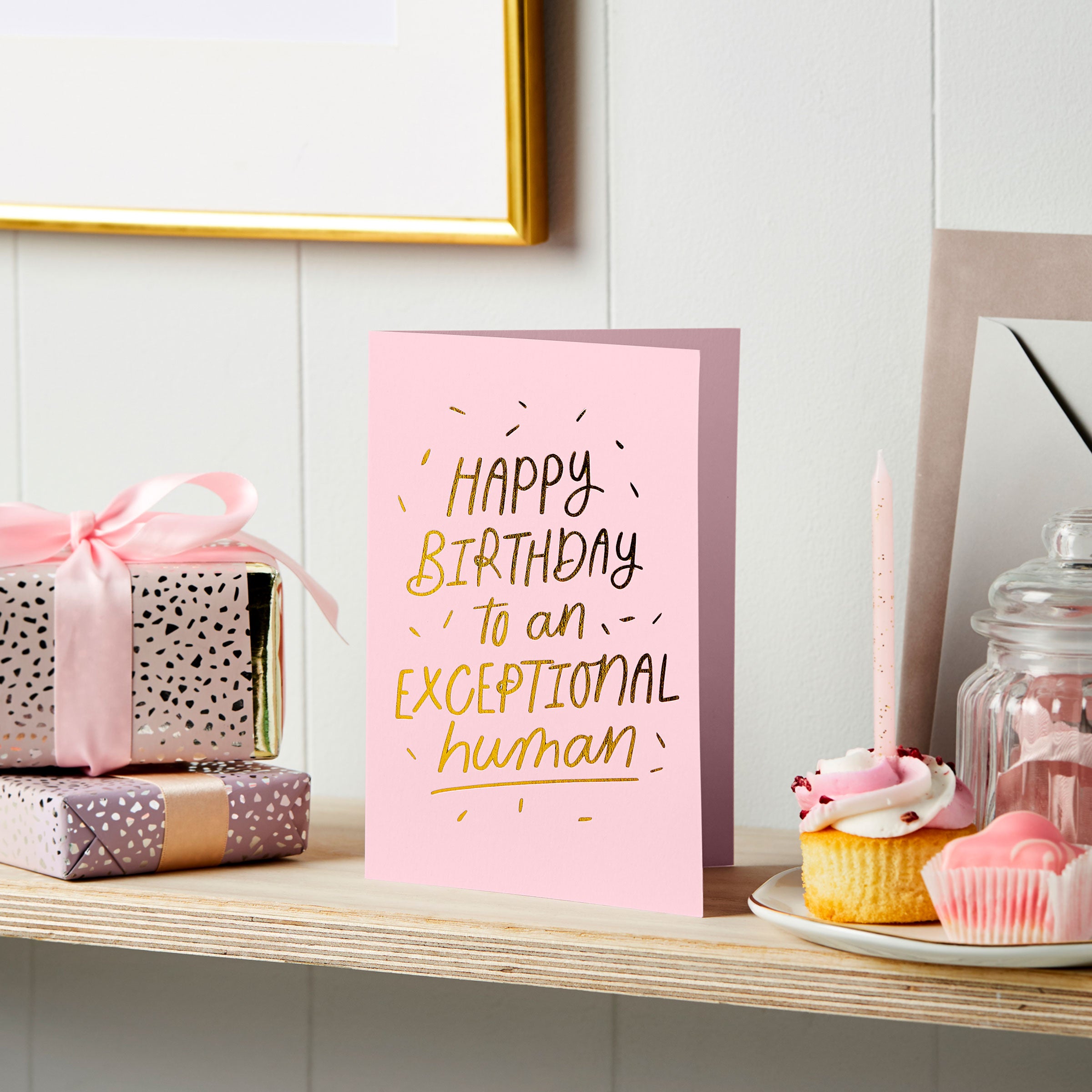 martha brook personalised stationery exceptional human foil embossed birthday card pink on a shelf with cake and candle