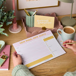 martha brook personalised stationery new goals weekly planner desk pad on desk with pink scalloped tray and motivational yellow postcard