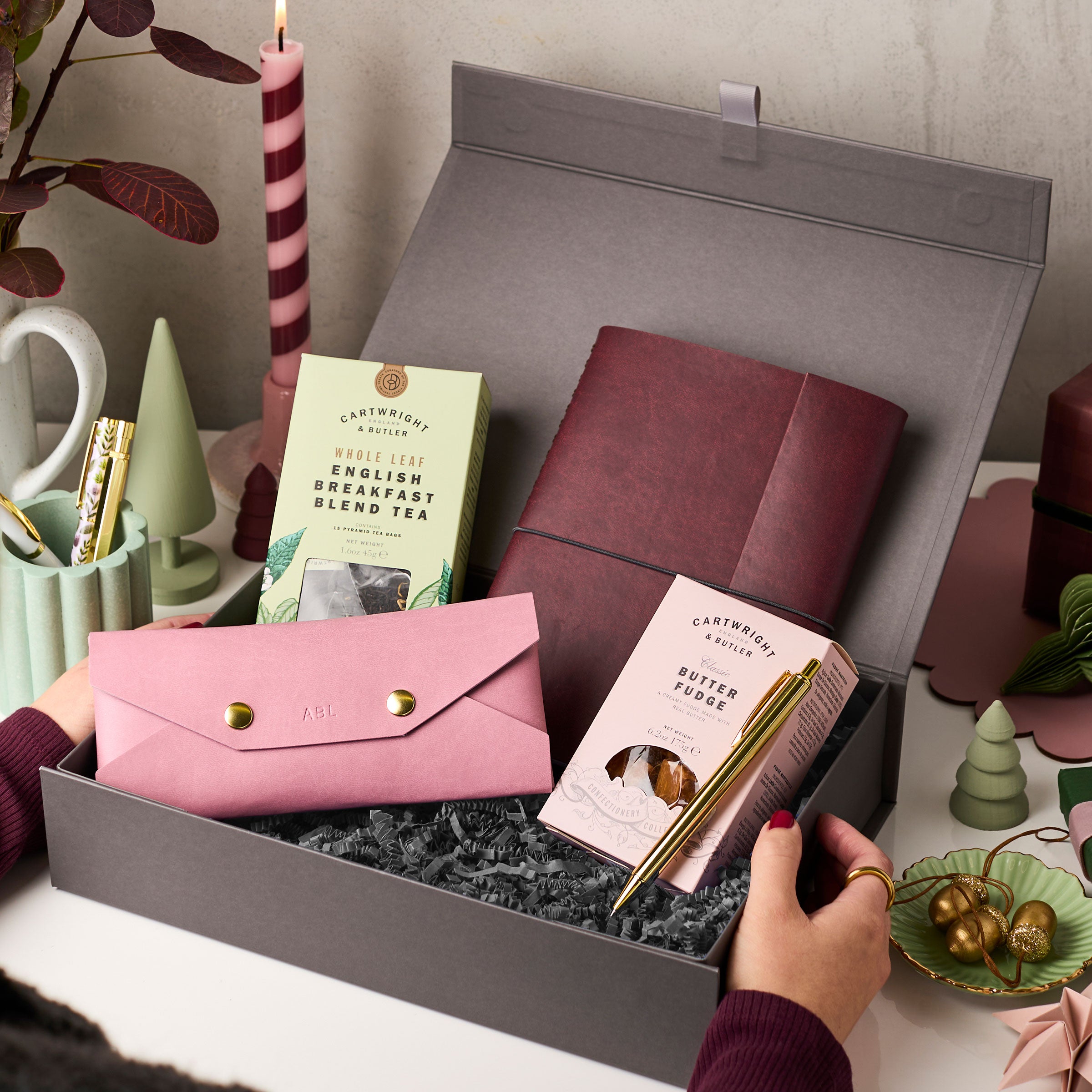 martha brook personalised stationery personalised christmas gift hamper open on desk with striped candle and christmas gifts