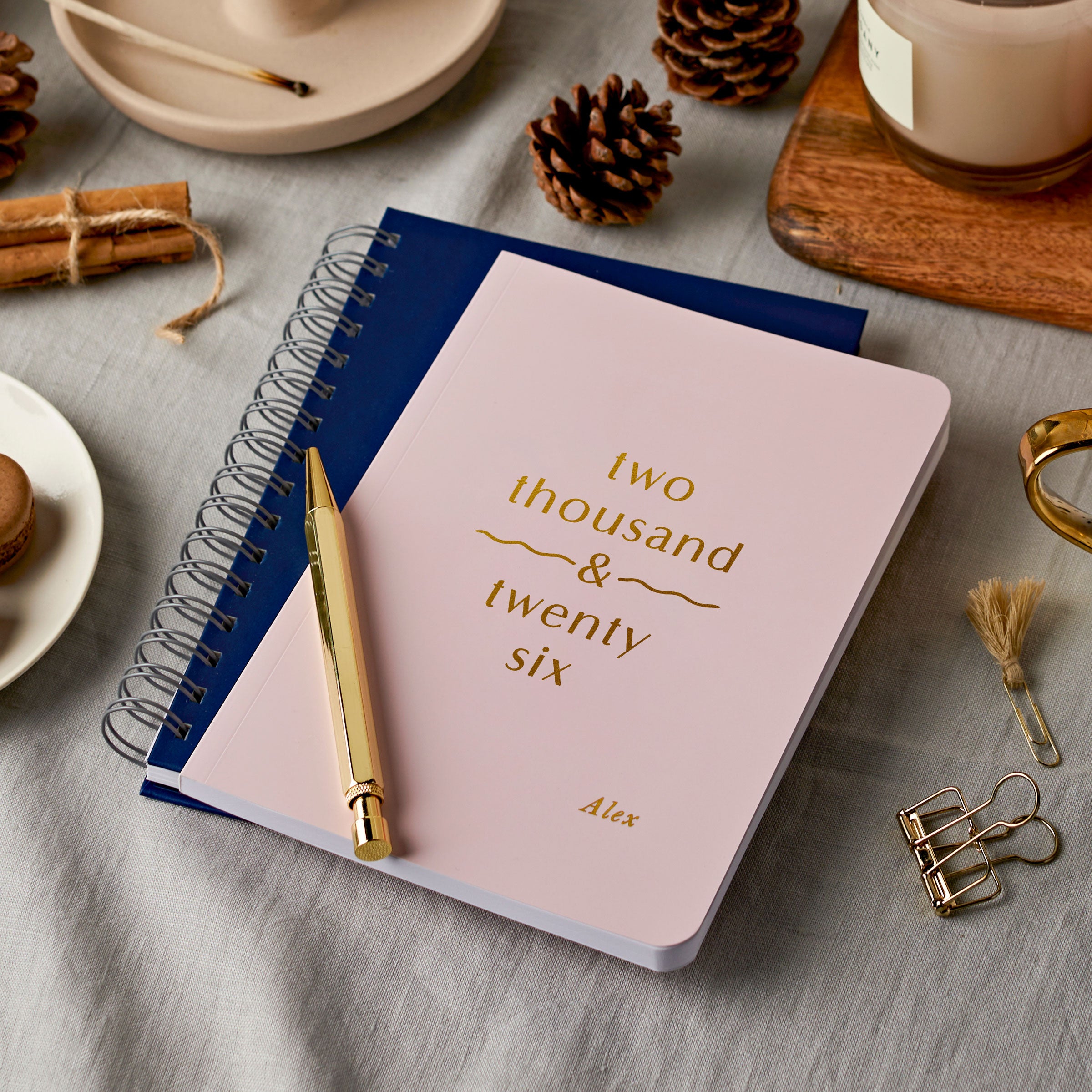 martha brook personalised future 2026 diary in blush pink and midnight blue on a grey cloth coloured desk with autumnal decorations and candles