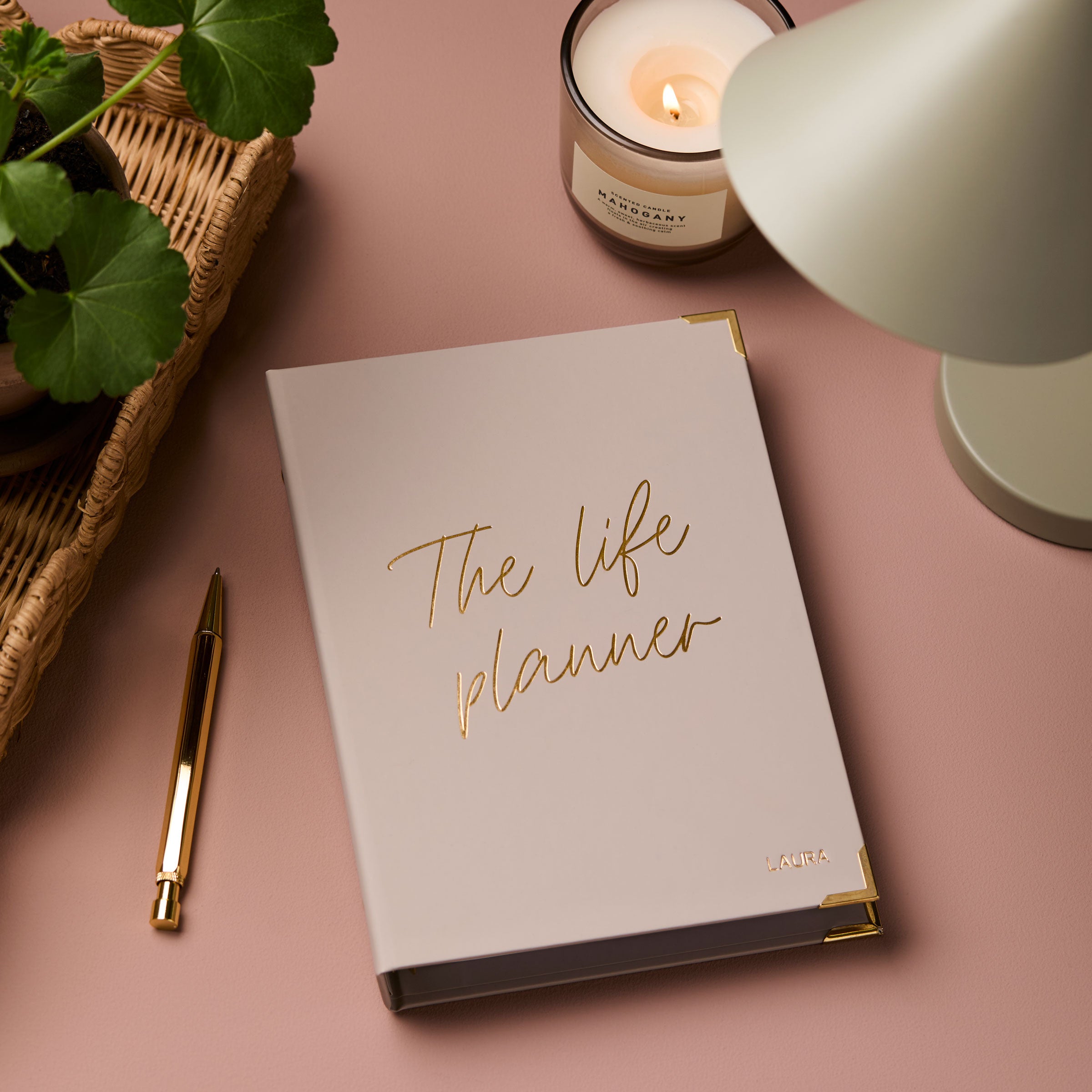 martha brook personalised stationery personalised life planner on a dusty pink background with a sage green desk lamp and rattan tray