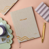 martha brook personalised stationery personalised ocean plastic notebooks personalised stay kind ocean plastic notebook sustainable notebook on desk with glass of water and candle
