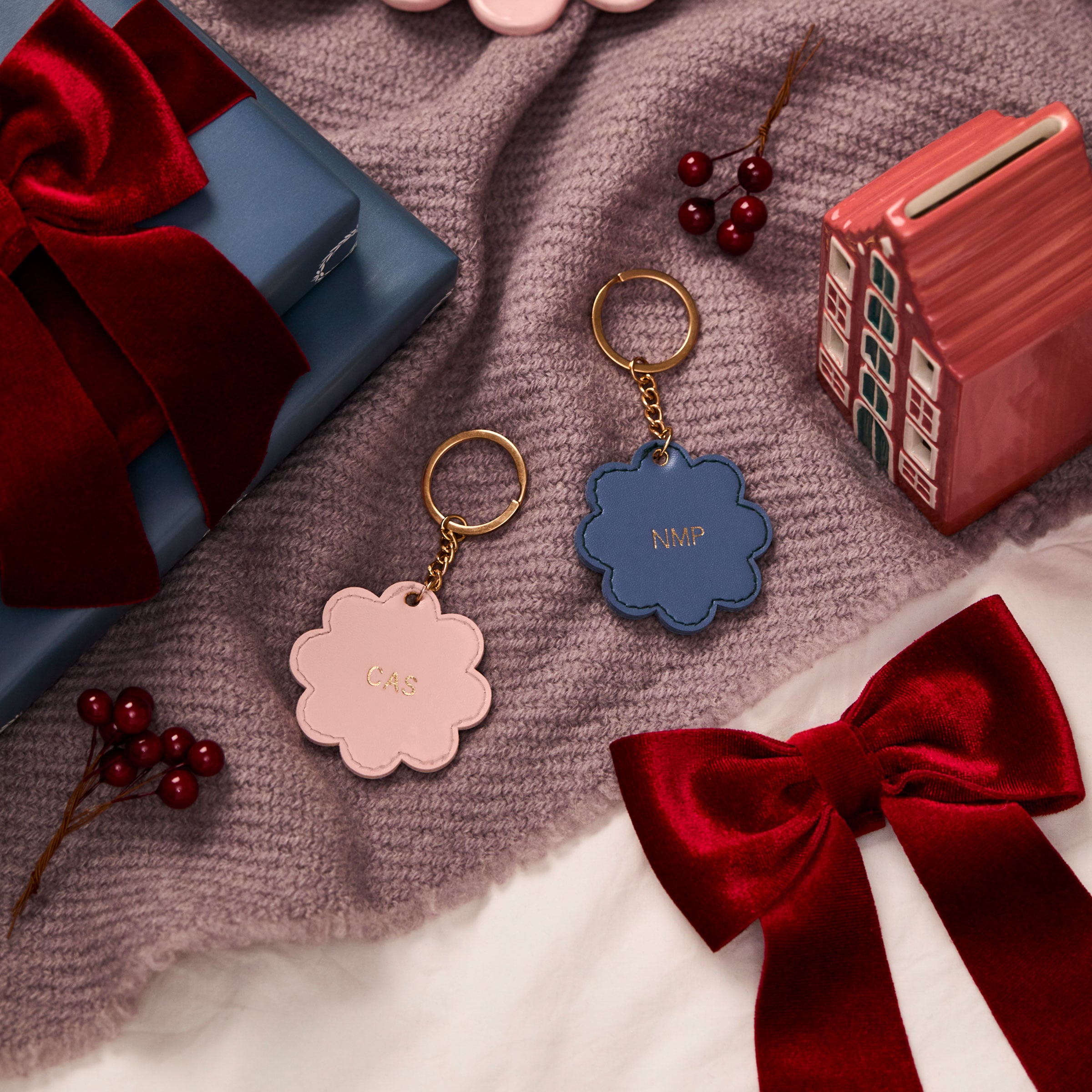 martha brook personalised stationery personalised scalloped key ring on a dusty purple blanket with deep red velvet ribbons and a painted ceramic house