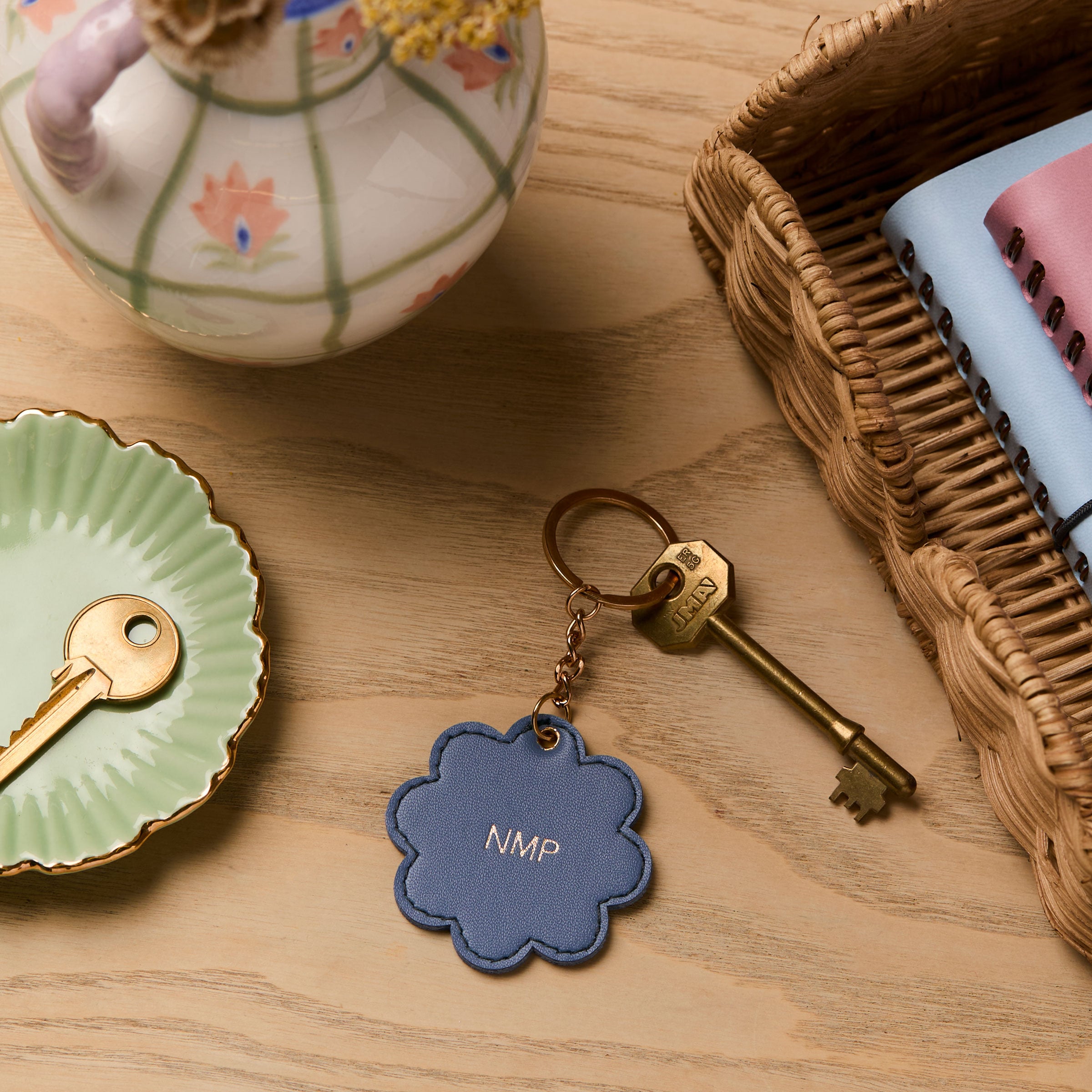 martha brook personalised stationery personalised scalloped key ring on a wooden desk with a rattan scalloped tray and hand painted dried flower vase