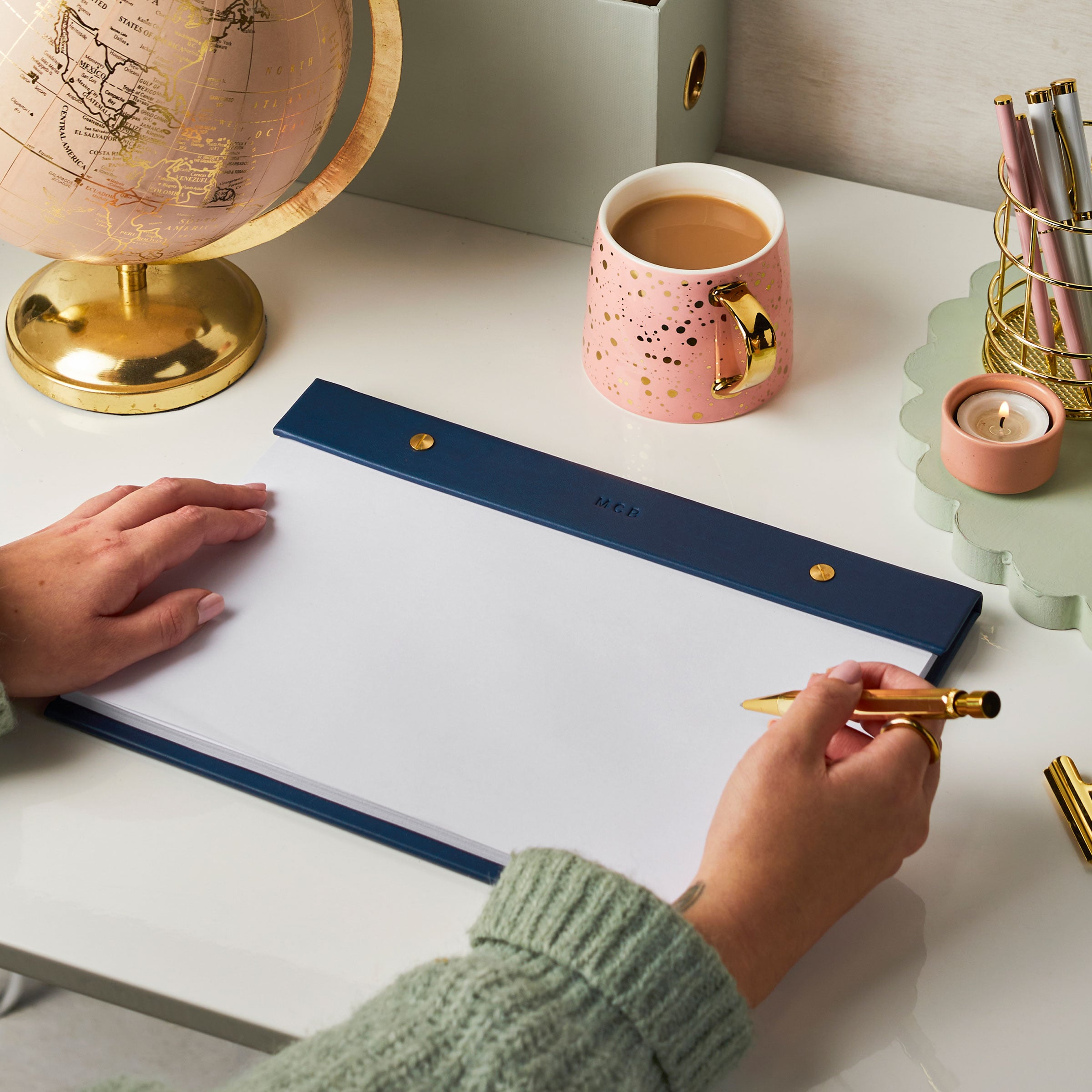 martha brook personalised stationery personalised vegan leather a4 refillable desk pad navy on desk with pink globe and magazine holder