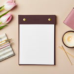 martha brook personalised stationery personalised vegan leather winter berry refillable notepad on a soft apricot colour background with a marbled pen holder and candle