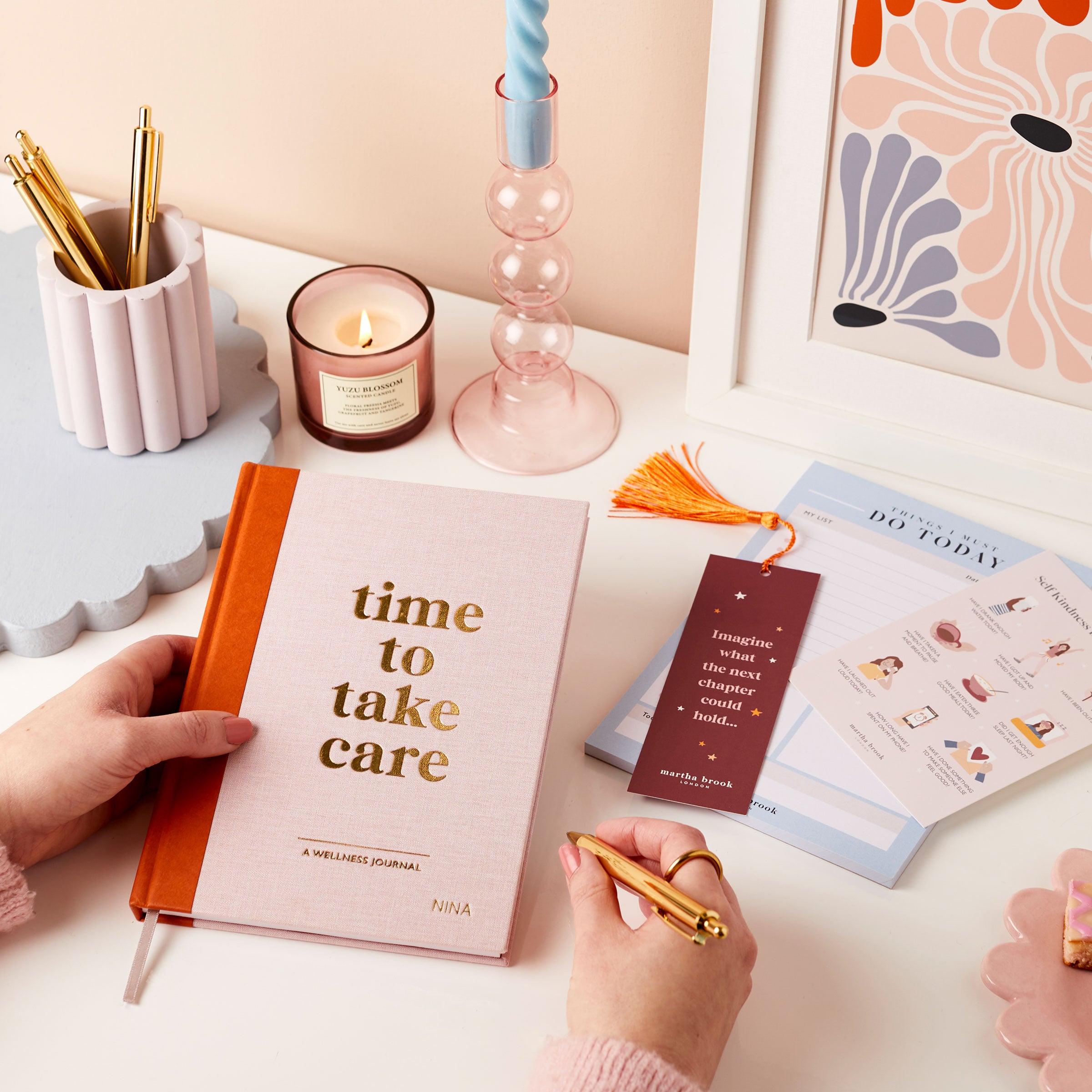 martha brook personalised stationery personalised wellness gift set wellness journal happiness daily planner pad post card gold pen on desk with candle and art print with hands