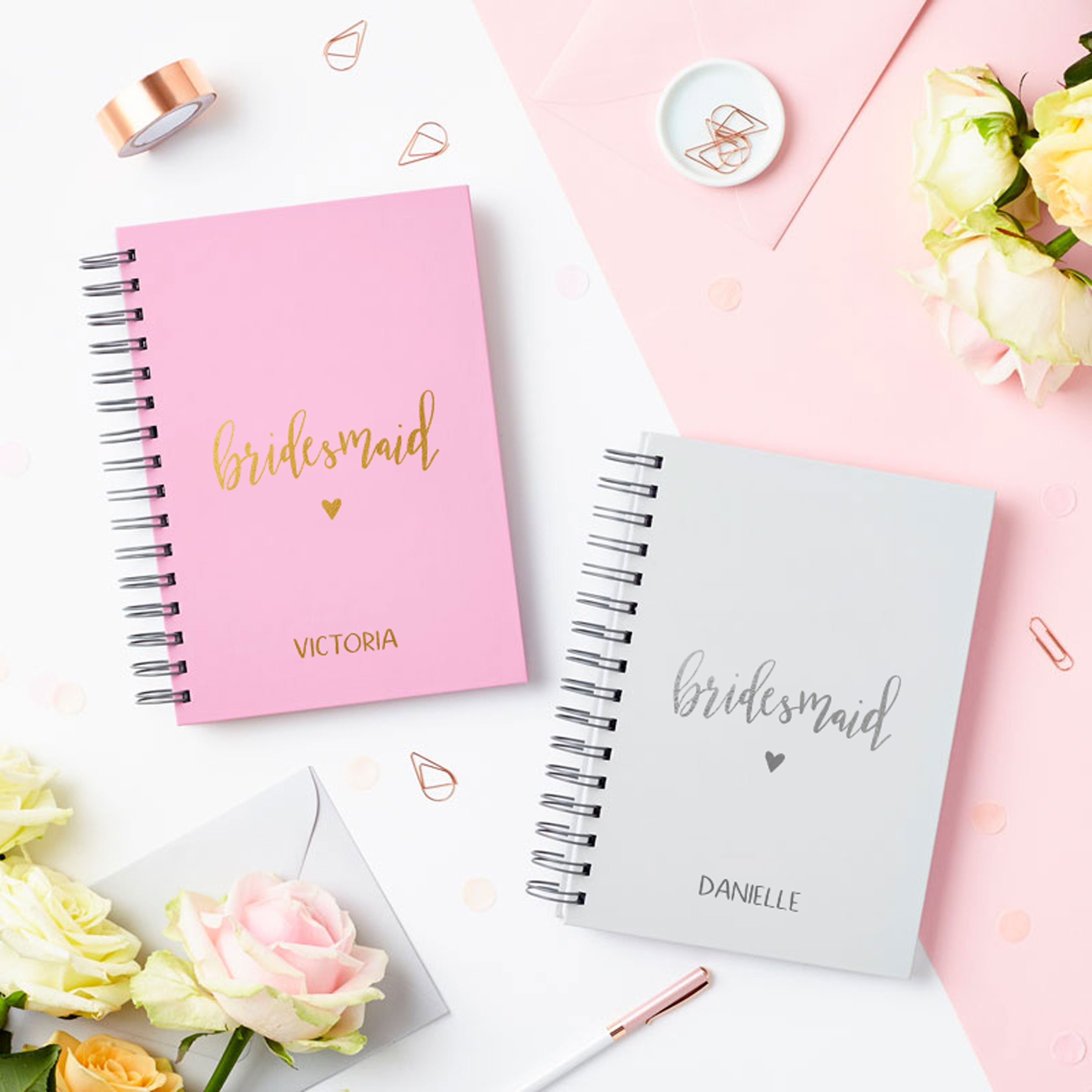 martha brook personalised stationery script bridesmaid notebook in pebble grey on a table next to matching script bridesmaid notebook in rose pink