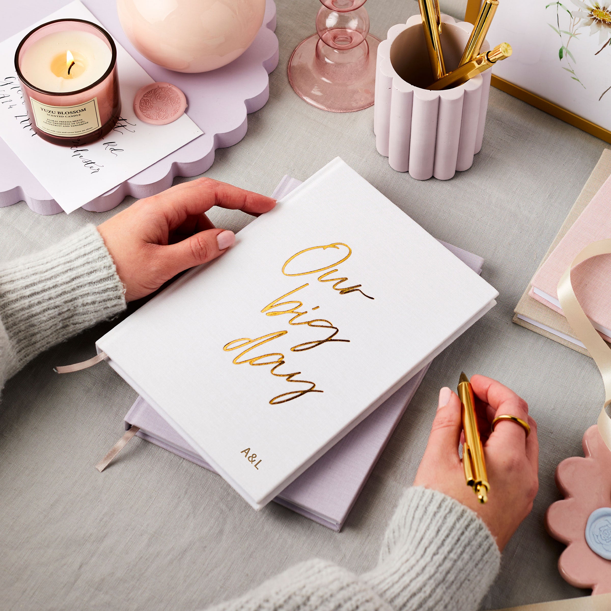 martha brook personalised stationery wedding stationery personalised linen wedding notebooks stacked in ivory white and lilac with candles and flowers