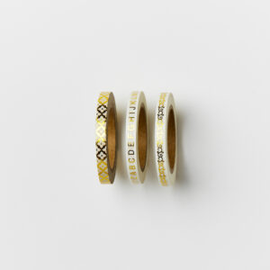 Set of three thin gold washi tape on a white table