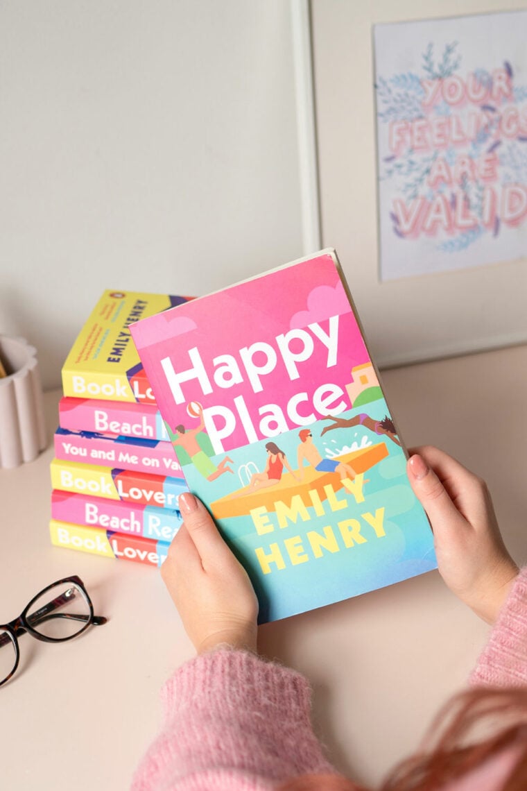 martha brook blog post a review of Happy Place by Emily Henry a girl holding a copy of Happy Place