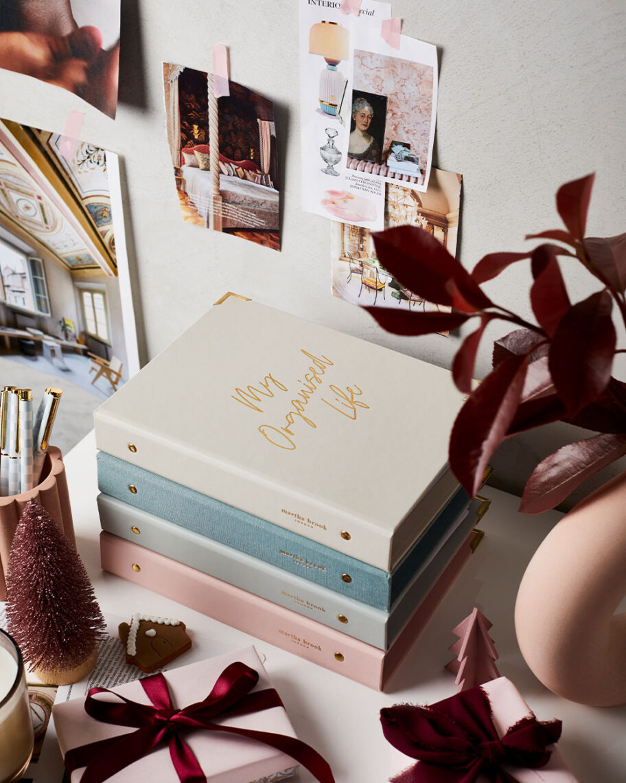 martha brook blog post what is a life planner martha brook life planners stacked on a desk next to pen pot with autumnal leaves and moodboard on wall