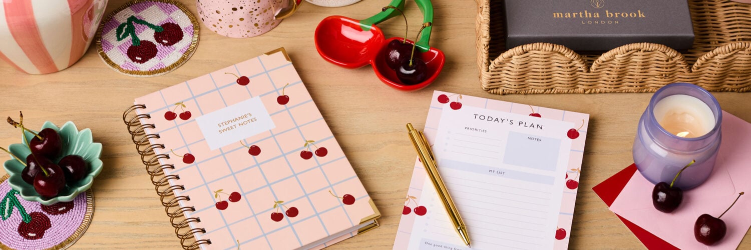 martha brook 10 unique cherry themed gifts for her cherry themed stationery gift set notebook deskpad and gold pen in gift box laid out on desk