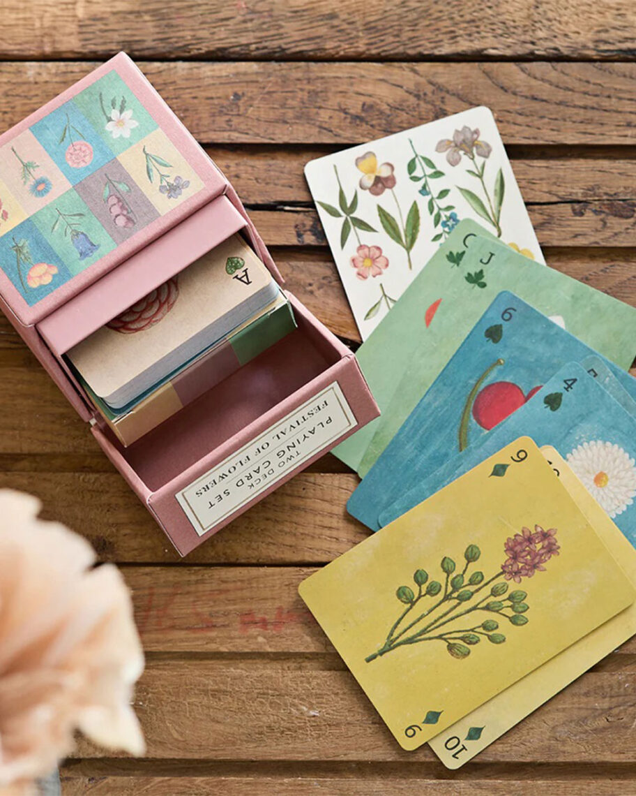 martha brook personalised stationery blog 15 things to take on holiday that you’ll wish you’d thought of sooner travel games. An open pack of cards is laid out on a table. The cards are different colours and all have illustrations of flowers on them