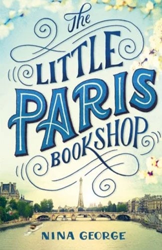 Martha Brook personalised stationery blog 20 best summer reads from old classics to new releases. The Little Paris Bookshop by Nina George. The background is a view of the eiffel tower with trees either side, with a lot of sky and space above it. The title of the novel and the author name are in the sky in very decorative blue lettering.
