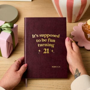 martha brook personalised stationery personalised 21st birthday gift softback notebook main image a dark red vegan leather notebook reads 'it's supposed to be fun turning 21' in gold foil