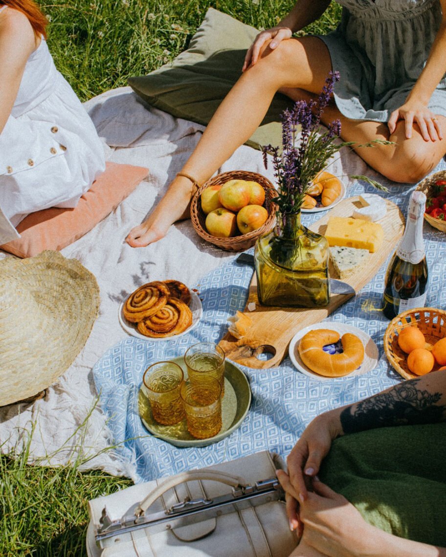 Martha Brook personalised stationery blog 10 ideas for what to get the person who has everything mystery picnic. Group of people sat on a picnic blanket with food