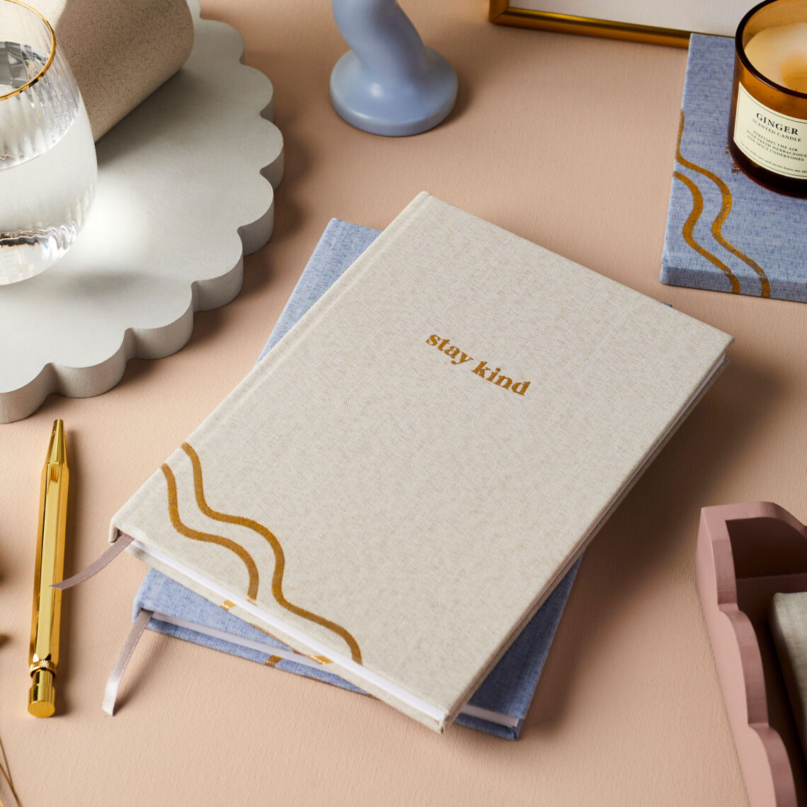 martha brook stationery ocean plastic notebooks personalised stay kind ocean plastic notebook sustainable notebook on desk with glass of water and candle